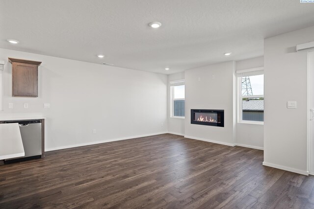 691 S Zeelar St, Kennewick, WA 99336 - unfurnished living room with dark wood-type flooring, recessed lighting, a glass covered fireplace, and baseboards