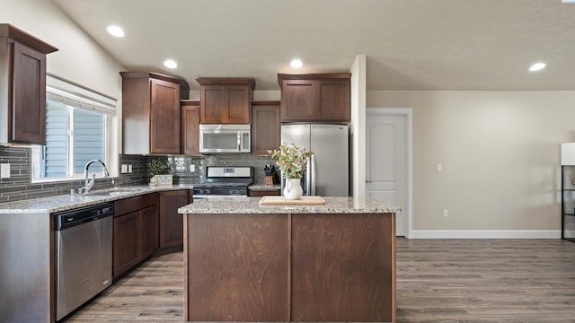5817 Ramus Ln, Pasco, WA 99301 - kitchen with decorative backsplash, appliances with stainless steel finishes, wood finished floors, a sink, and baseboards