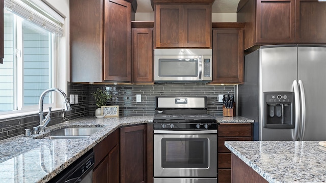 5817 Ramus Ln, Pasco, WA 99301 - kitchen with a sink, appliances with stainless steel finishes, decorative backsplash, and light stone countertops