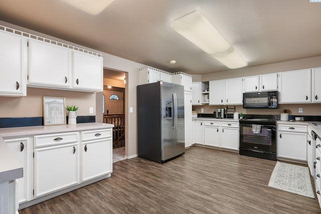 kitchen with black appliances, dark wood-style floors, and white cabinets