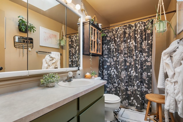 full bath with toilet, vanity, a shower with shower curtain, and a skylight