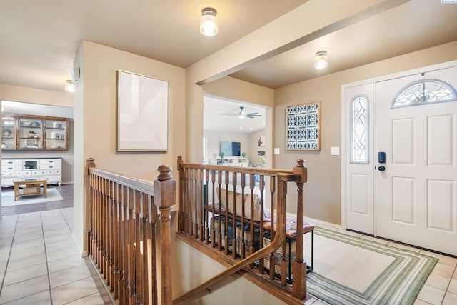foyer with a ceiling fan, baseboards, and light tile patterned floors