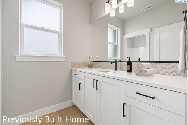 bathroom featuring vanity, decorative backsplash, and wood-type flooring