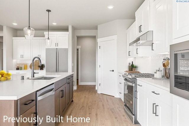 kitchen featuring sink, decorative light fixtures, stainless steel appliances, and white cabinets