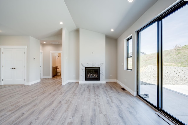 590 SW Cayuse St, Pullman, WA 99163 - unfurnished living room with recessed lighting, vaulted ceiling, a high end fireplace, and light wood-style floors