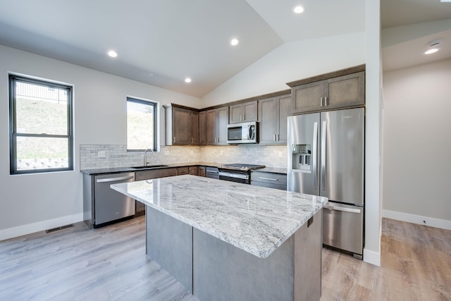 590 SW Cayuse St, Pullman, WA 99163 - kitchen with lofted ceiling, light stone countertops, a center island, a sink, and stainless steel appliances