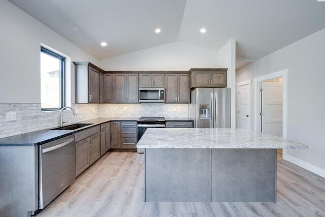 590 SW Cayuse St, Pullman, WA 99163 - kitchen with a kitchen island, light wood-type flooring, a sink, appliances with stainless steel finishes, and vaulted ceiling