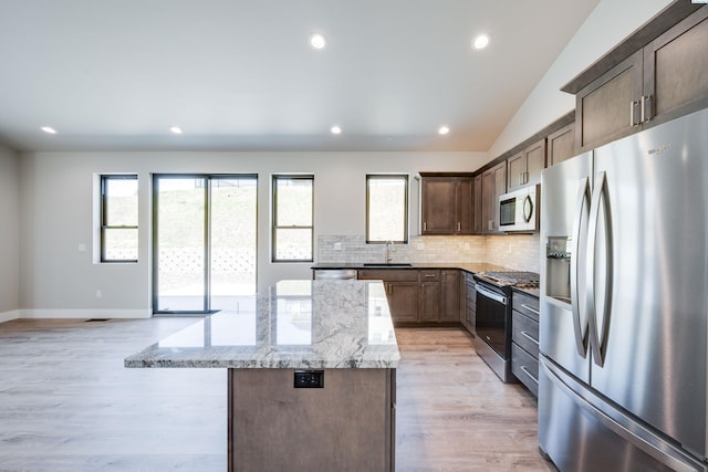 590 SW Cayuse St, Pullman, WA 99163 - kitchen featuring a kitchen island, light wood-style floors, open floor plan, white cabinets, and light stone counters