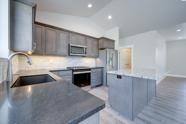 590 SW Cayuse St, Pullman, WA 99163 - kitchen with appliances with stainless steel finishes, a sink, light wood-style floors, a center island, and lofted ceiling