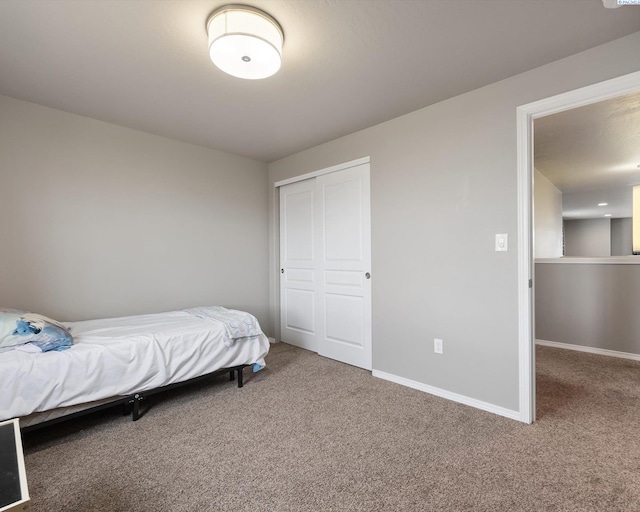 bedroom featuring a closet, baseboards, and carpet flooring