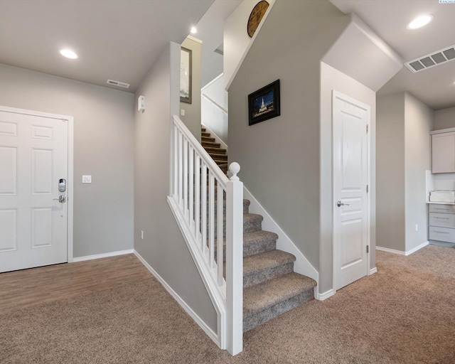 stairs with baseboards, visible vents, and carpet flooring