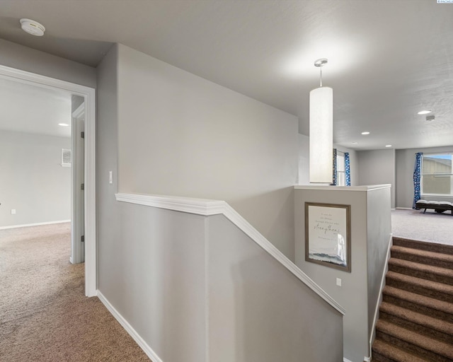 hallway featuring recessed lighting, carpet, baseboards, and an upstairs landing