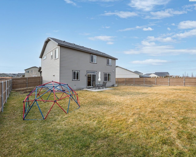 back of property featuring board and batten siding, a fenced backyard, a patio, and a lawn