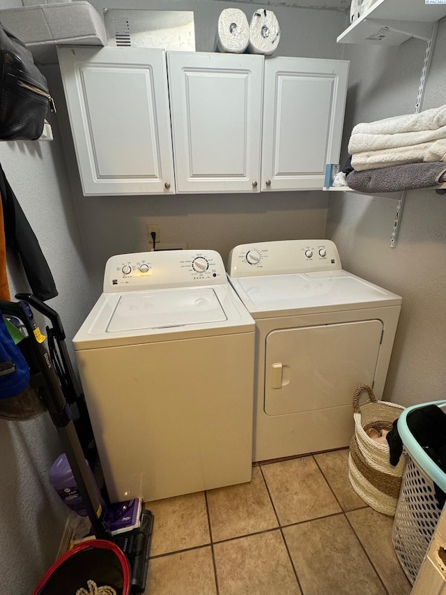 laundry room featuring cabinet space, light tile patterned floors, and independent washer and dryer