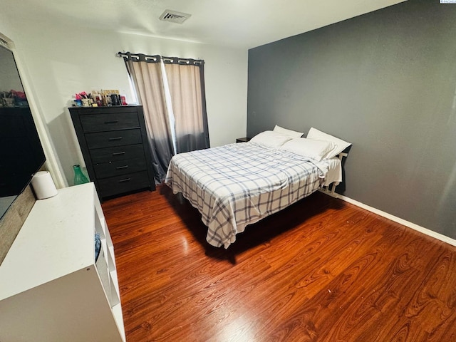 bedroom with baseboards, visible vents, and dark wood-style flooring