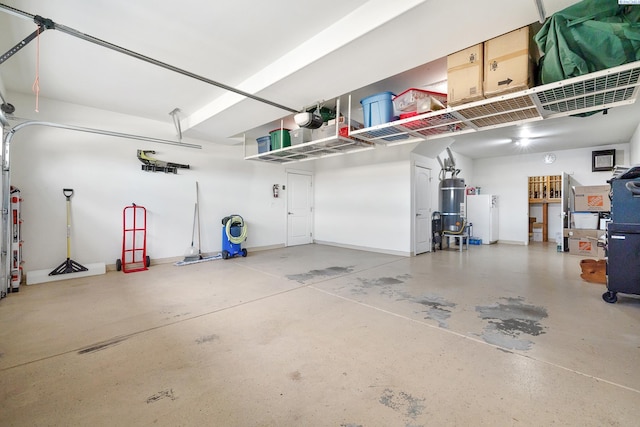 garage with water heater, strapped water heater, and freestanding refrigerator