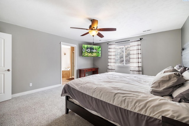 carpeted bedroom featuring visible vents, ceiling fan, ensuite bath, and baseboards