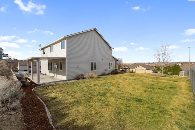 rear view of property featuring a patio, a yard, and fence