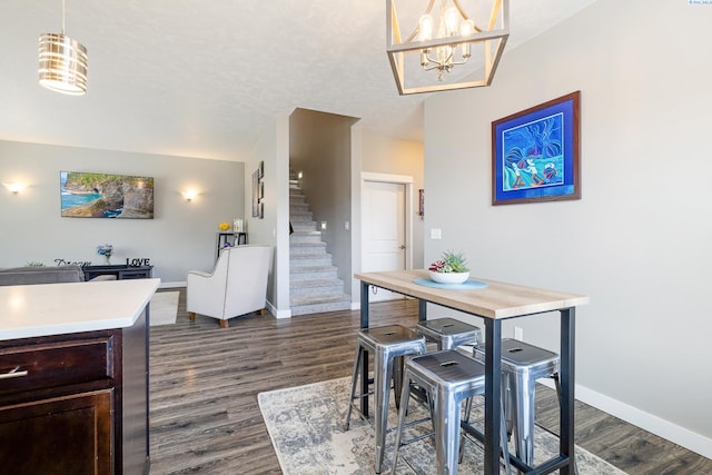 dining area with dark wood-style flooring, baseboards, and stairs