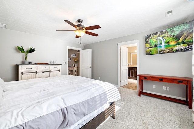 bedroom featuring connected bathroom, light colored carpet, a ceiling fan, baseboards, and visible vents