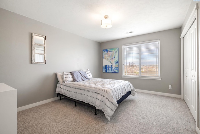 bedroom featuring a closet, carpet, visible vents, and baseboards