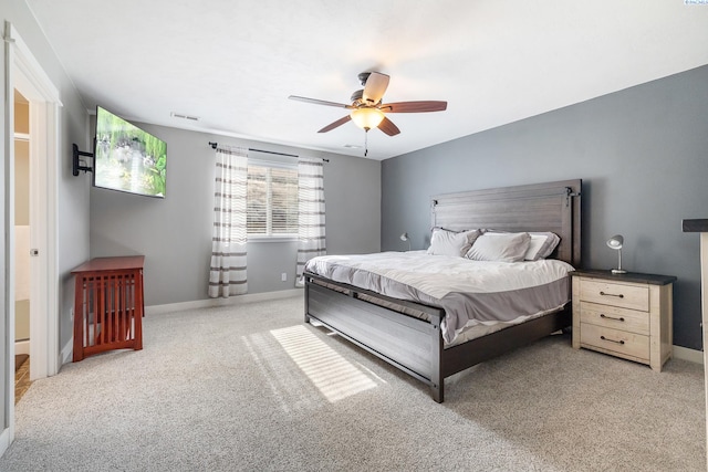 carpeted bedroom featuring a ceiling fan, visible vents, and baseboards