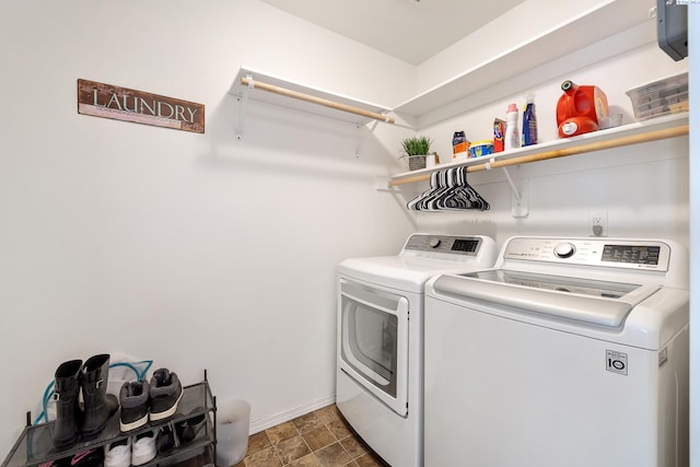 clothes washing area featuring laundry area, baseboards, and separate washer and dryer