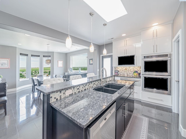 5880 S 58th Ave, West Richland, WA 99353 - kitchen with stainless steel appliances, a center island with sink, white cabinetry, plenty of natural light, and recessed lighting