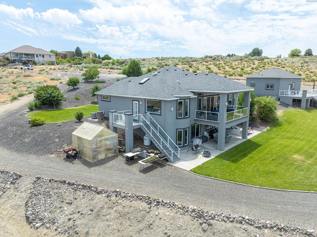 5880 S 58th Ave, West Richland, WA 99353 - rear view of house with a greenhouse, a patio area, a yard, an outbuilding, and a deck