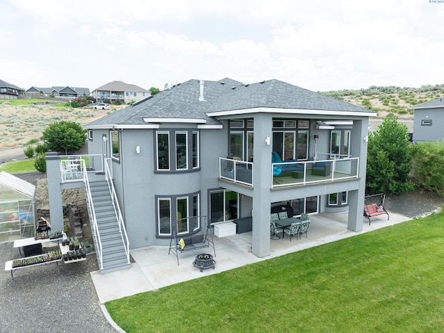 5880 S 58th Ave, West Richland, WA 99353 - back of property featuring a fire pit, a patio, stucco siding, and a lawn