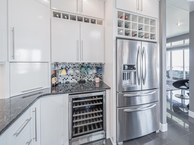 5880 S 58th Ave, West Richland, WA 99353 - kitchen featuring stainless steel fridge, wine cooler, backsplash, white cabinets, and dark stone counters