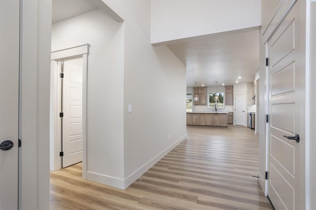 corridor with light wood-style floors, baseboards, and recessed lighting