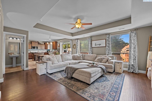 5200 W 28th Ave, Kennewick, WA 99338 - living area featuring a tray ceiling, ceiling fan, plenty of natural light, and dark wood finished floors