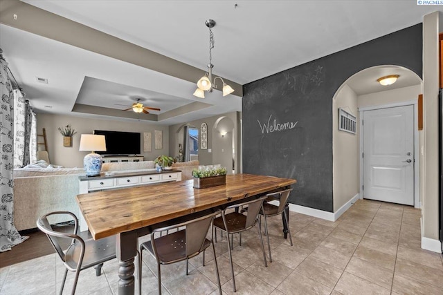 5200 W 28th Ave, Kennewick, WA 99338 - dining room with arched walkways, a ceiling fan, a raised ceiling, baseboards, and light tile patterned floors
