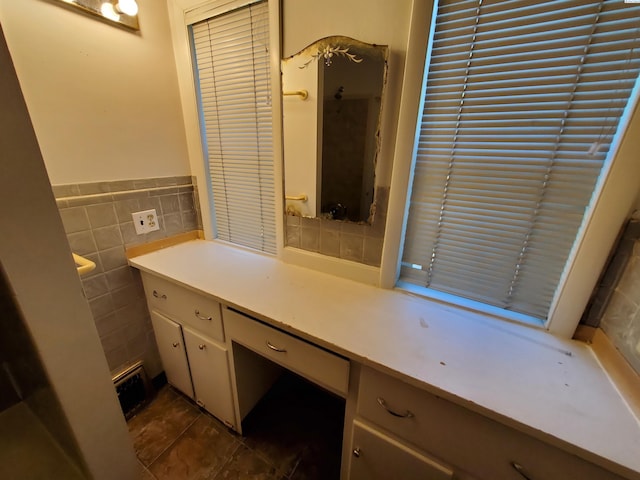 bathroom featuring tile patterned flooring, vanity, a wainscoted wall, and tile walls