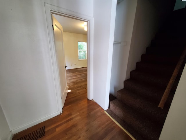 stairs with baseboards, visible vents, and wood finished floors