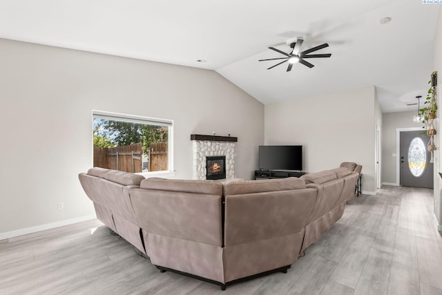 1335 W Grandview Ave, Sunnyside, WA 98944 - living room featuring a ceiling fan, light wood finished floors, a stone fireplace, healthy amount of natural light, and vaulted ceiling