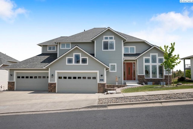 970 SW Itani Dr, Pullman, WA 99163 - craftsman-style house with stone siding, driveway, roof with shingles, and an attached garage