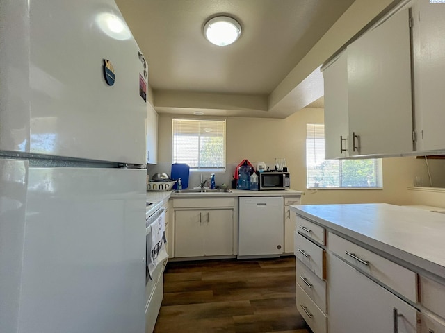 kitchen featuring white cabinetry, dark hardwood / wood-style flooring, sink, and white appliances