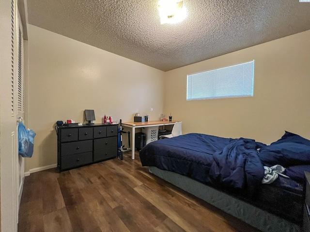 bedroom with dark wood-type flooring and a textured ceiling