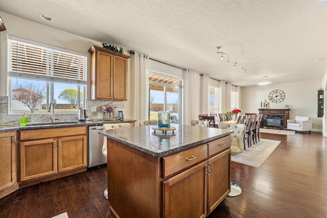 5601 Santa Fe Ln, Pasco, WA 99301 - kitchen with brown cabinetry, a kitchen island, backsplash, and dark wood-style flooring