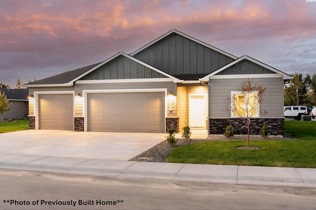 craftsman-style home with a garage and a lawn