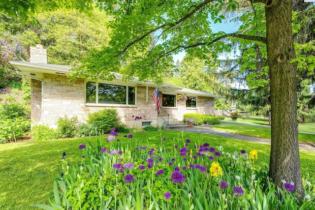 609 N Perkins Ave, Colfax, WA 99111 - view of front of house featuring a chimney, a front lawn, stone siding, and entry steps