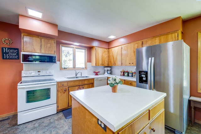 609 N Perkins Ave, Colfax, WA 99111 - kitchen featuring appliances with stainless steel finishes, a sink, backsplash, light countertops, and a center island