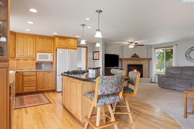 96604 E Clover Rd, Kennewick, WA 99338 - kitchen featuring white appliances, ceiling fan, a kitchen bar, light wood-type flooring, and recessed lighting