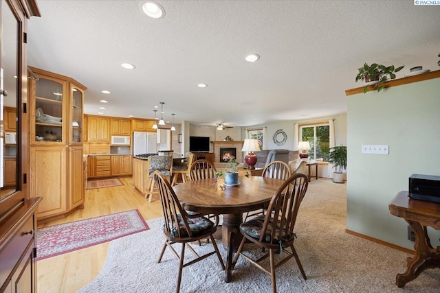 96604 E Clover Rd, Kennewick, WA 99338 - dining room with a ceiling fan, recessed lighting, a textured ceiling, and a warm lit fireplace