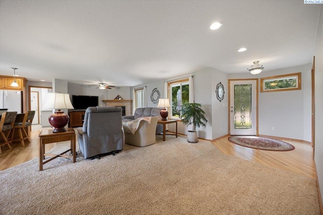 96604 E Clover Rd, Kennewick, WA 99338 - living area with light wood finished floors, a fireplace, recessed lighting, and a ceiling fan