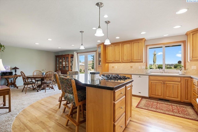 96604 E Clover Rd, Kennewick, WA 99338 - kitchen with white dishwasher, a kitchen island, decorative backsplash, recessed lighting, and a kitchen bar