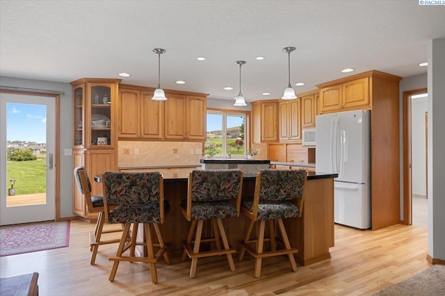 96604 E Clover Rd, Kennewick, WA 99338 - kitchen featuring white appliances, decorative backsplash, a kitchen island, recessed lighting, and light wood-style floors