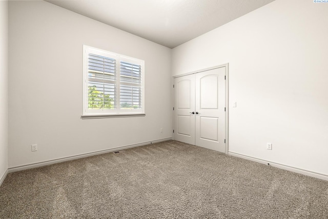 carpeted empty room featuring baseboards